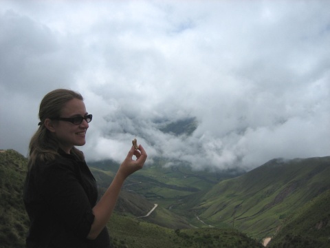 Rebecca eats an alfajor while enjoying a view of Valle Encantado.